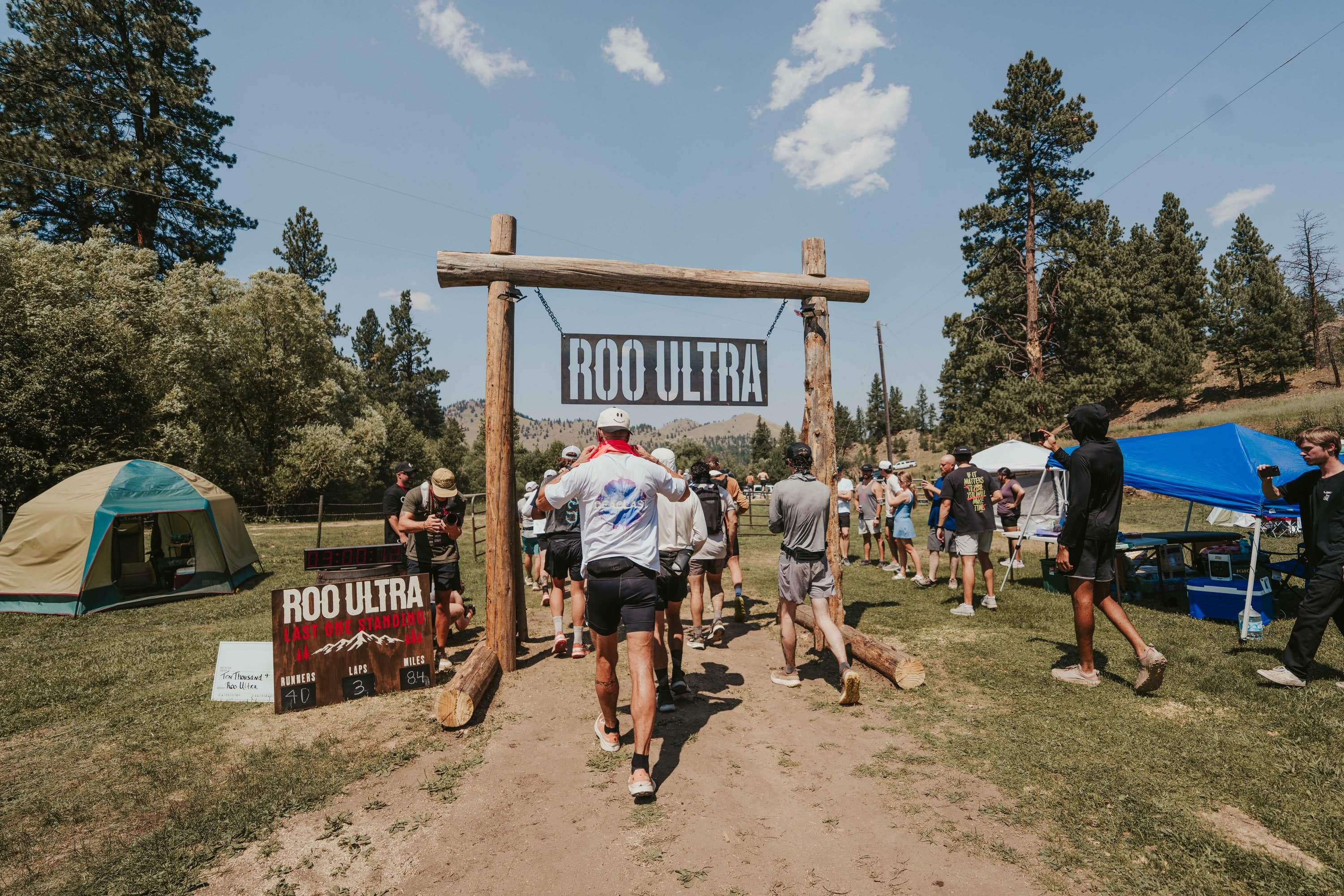 Runners beneath the ROO Ultra arch as the scoreboard tracks the shrinking field
