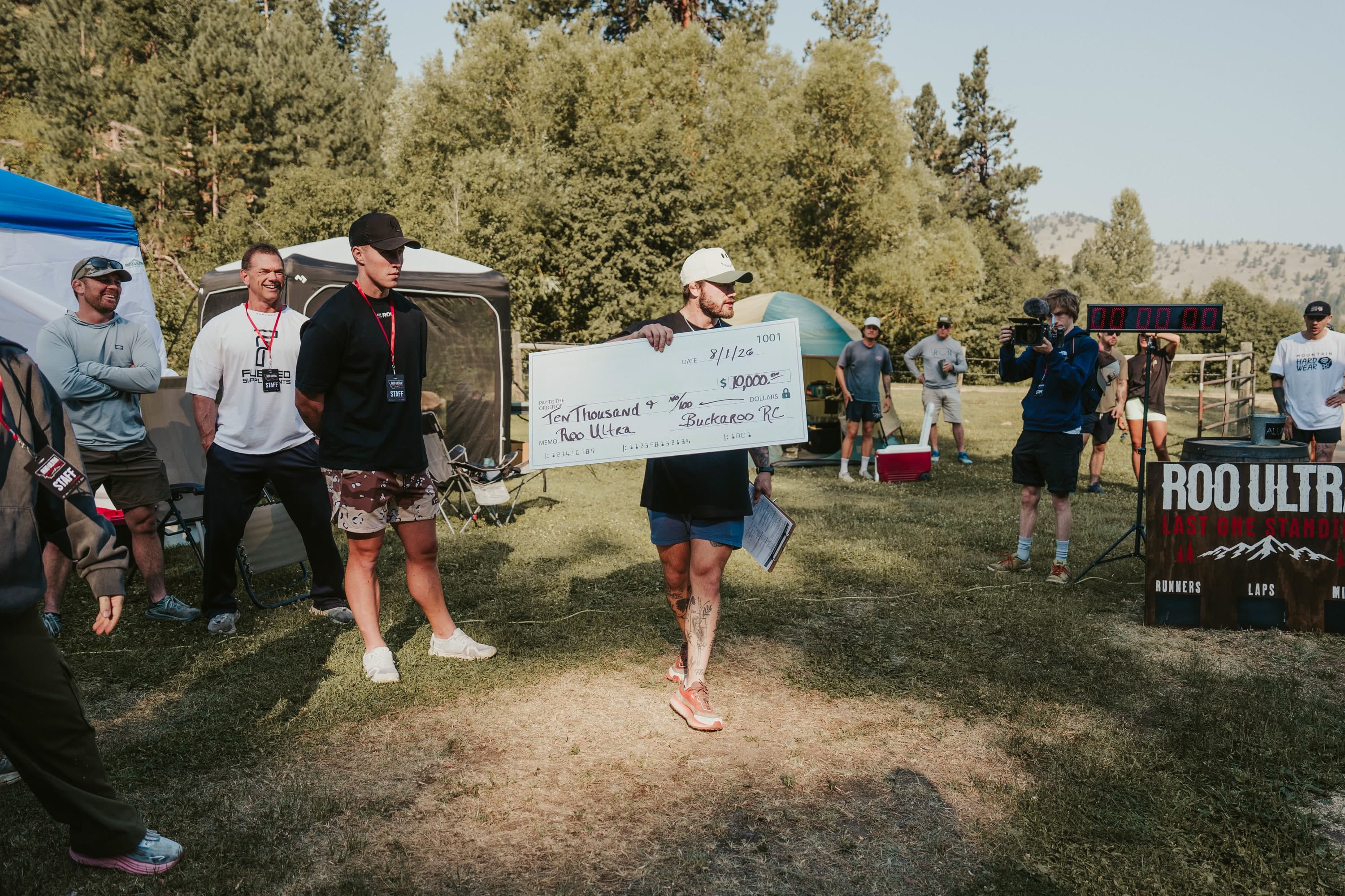 The ROO Ultra winner carrying the $10,000 prize check through camp